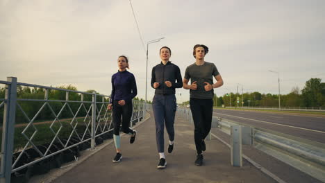 young-friends-are-running-together-in-morning-along-road-in-city-keeping-fit-and-healthy-lifestyle